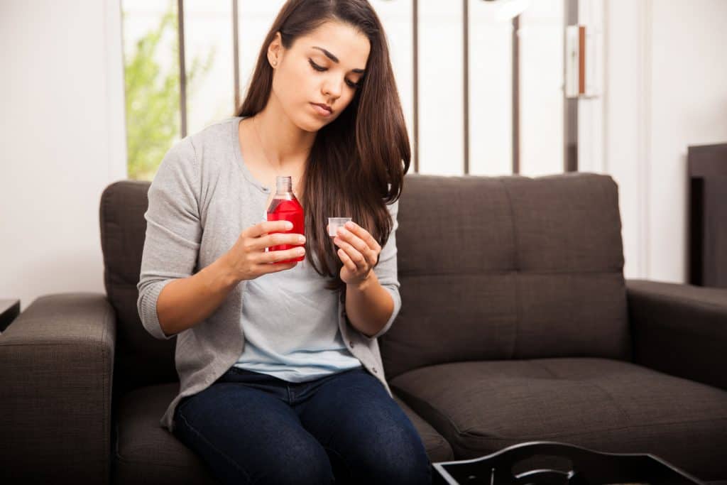 A woman measure the calories in cough syrup
