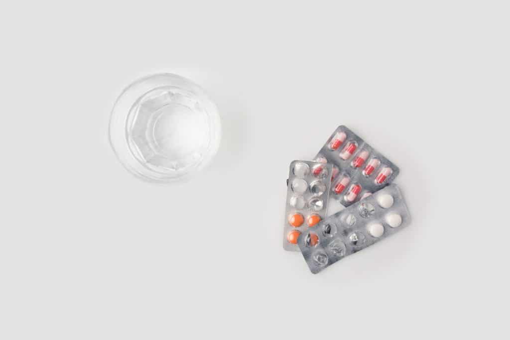 A Glass of water next to pill packs, symbolizing the importance of knowing how to make Adderall more effective