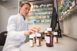 Can a doctor cancel a prescription? A pharmacist sits with pill bottles as he prepares for a doctor to cancel a prescription.