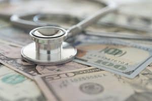 a stethoscope on money, representing the lack of affordable prescriptions avaible.